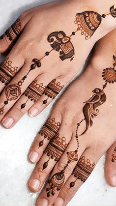 two hands with henna tattoos on them