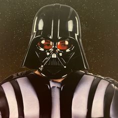 a darth vader mask with red eyes and black stripes on his chest is shown