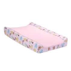 a pink baby crib mattress with princess images on the cover and bottom half, in front of a red frame