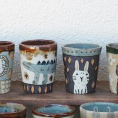 there are many cups that have animals on them in the same color and pattern as they stand next to each other