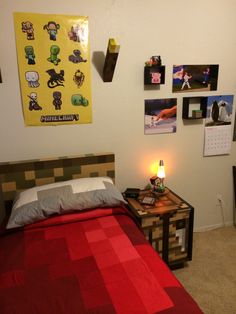 a bed with a red blanket sitting next to a night stand on top of it