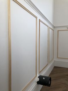 an empty room with white walls and wood trimmings on the wall, along with a black carpet