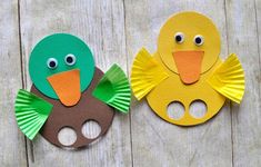 two paper plates with ducks on them sitting next to each other in front of a wooden background