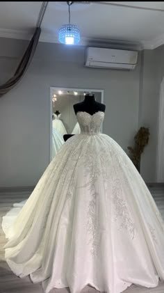 a wedding dress on display in front of a mirror