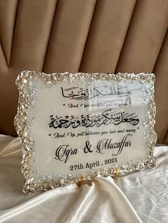 a wedding sign is sitting on top of a white cloth covered tablecloth with gold trimmings