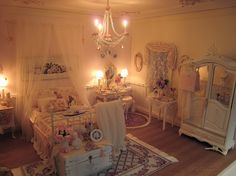 a bedroom with white furniture and chandelier hanging from the ceiling next to a bed