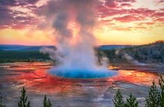 a geyser spewing water into the sky at sunset