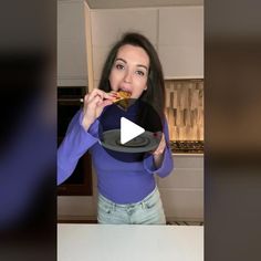 a woman is eating food in the kitchen