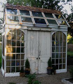 an old outhouse is being used as a greenhouse