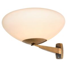 a wall light with a white glass shade on it's arm and wooden handle