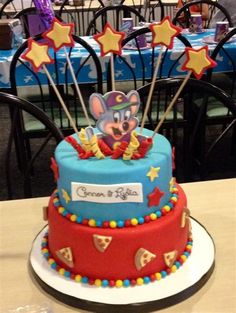 a birthday cake decorated with stars and a mouse on top is sitting on a table