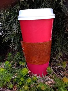 a pink coffee cup sitting in the grass