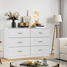 a living room scene with focus on the coffee table and white dresser in the foreground