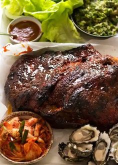 a steak, oysters and salad on a plate