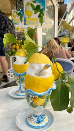 three lemon ice creams in blue and white dishes on a table with people sitting at tables behind them