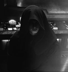 a person in a dark room with a hood on