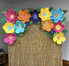 an arrangement of paper flowers in a wicker basket on top of a wooden table