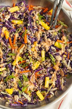 a salad with carrots, cabbage and other vegetables in a bowl on top of a table