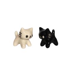 two small black and white cat figurines sitting next to each other