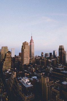 an aerial view of the city skyline at sunset or dawn, with skyscrapers in the foreground