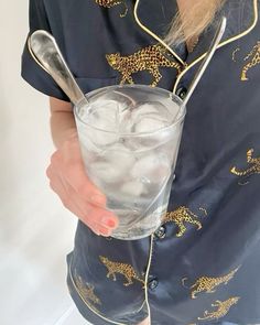 a woman holding a glass filled with ice