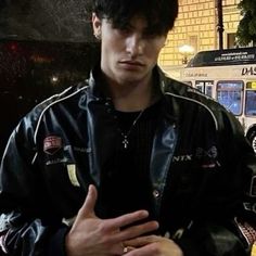 a young man standing in front of a bus