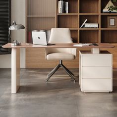 an office desk with a laptop on it and bookshelves in the back ground