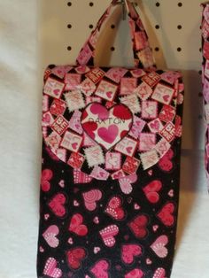 two bags with hearts on them hanging from hooks