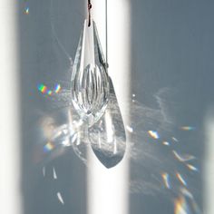 the sun shines on a glass hanging from a hook