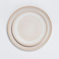 an empty white plate sitting on top of a table