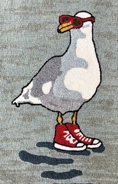 a seagull with red shoes is standing on the ground