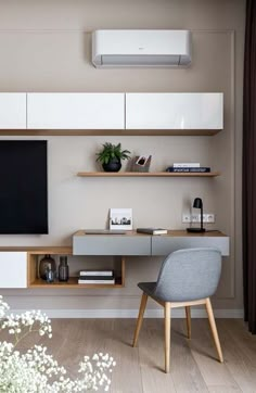 a modern living room with white and wood furniture, an entertainment center and a flat screen tv mounted on the wall