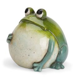 a green and white frog sitting on top of a white surface with eyes wide open