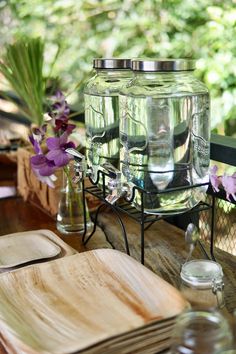 there are many glass jars on the table