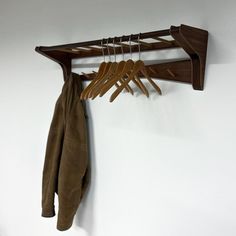 a coat rack with wooden hangers and leather jackets hanging from it's sides