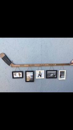 a hockey stick hanging from the side of a wall with pictures on it and an inscription that reads eat sleep play hockey