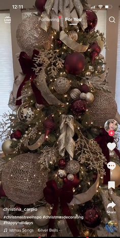 a christmas tree decorated with red and gold ornaments is shown on the phone's screen