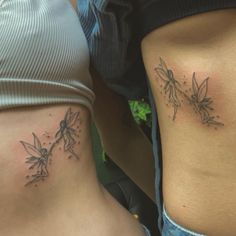 two women with tattoos on their stomachs, one has a flower and the other has a leaf