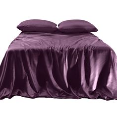 a bed with two pillows on top of it and a purple blanket over the headboard