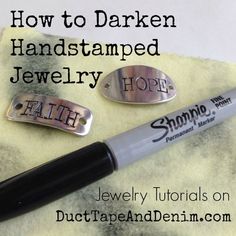 a pen sitting on top of a white towel next to two metal tags that say how to darken handstamped jewelry