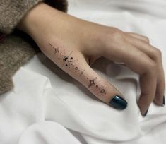 a woman's hand with a tattoo on it