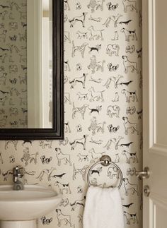 a white sink sitting under a bathroom mirror next to a wall mounted faucet