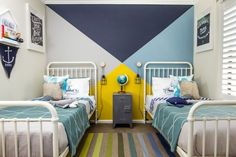 two beds in a room with blue and yellow walls