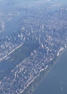 an aerial view of a large city with tall buildings and lots of water in the foreground