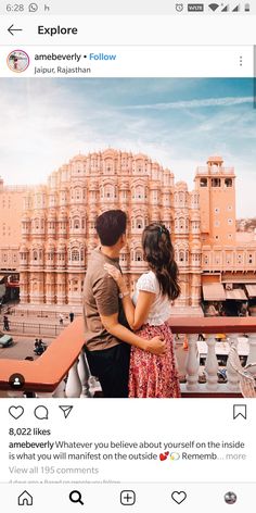 two people standing next to each other in front of a building with pink flowers on it