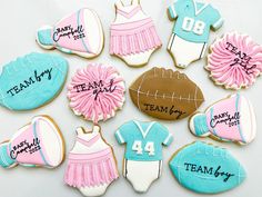 decorated cookies with pink, blue and white icing are arranged in the shape of football uniforms