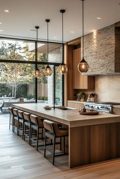 a large kitchen with an island and lots of lights hanging from it's ceiling