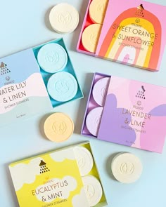 four soaps in different colors and designs on a blue surface with the label sweet orange & sunflower