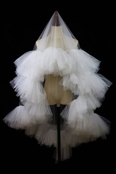 a mannequin with white tulle on it's head and neckline