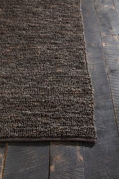 a brown rug is laying on the floor with wood planks in front of it